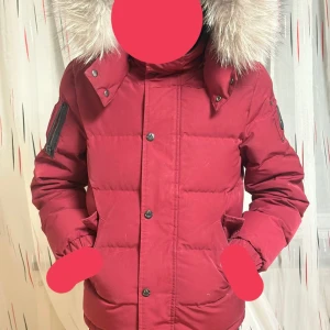 Röd Moose Knuckles dunjacka med päls - Säljer en röd dunjacka från Moose Knuckles med fluffig päls på huvan och snygga detaljer som logopatch på ärmen och broderad insida. Jackan har dragkedja, knappar och flera fickor. Perfekt för kalla vinterdagar och riktigt stilren look. Använd ett par gånger. St är M skulle samt säga att jackan passar 10-12. Ny mosse knuckles jacka kostar ca 4500 och säljer den för 1599 hör av er om ni vill sänka priset😃.
