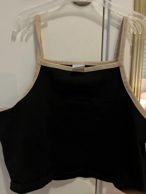 Svart linne/topp- strl 146-152 - Säljer detta svarta ganska korta linne med bruna kanter  då det int kommit till andväning på väldigt länge 💕 strl 146-52🫰🏼