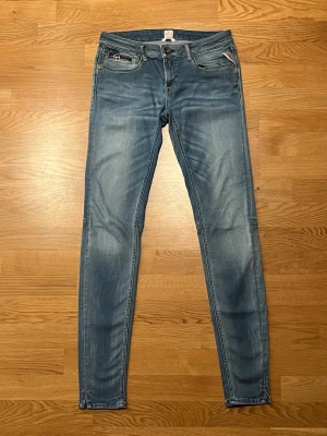 Replay skinny W29 L32 - Snygga ljusblå skinny jeans från Replay med klassisk femficksdesign och diskreta slitningar. Jeansen har dragkedjegylf och detaljerade bakfickor. Perfekta för dig som gillar en smal passform och stilren look.