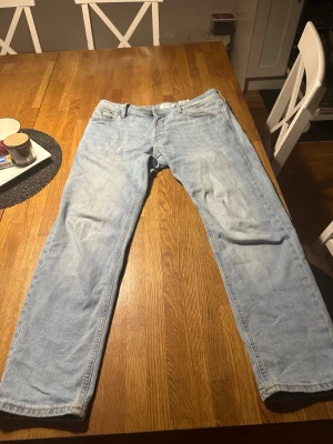 Ljusblå tapered jeans Tapered/Mike - Snygga ljusblå jeans med tapered passform från Tapered/Mike. Klassisk femficksmodell med raka ben och normal midja. Jeansen är tillverkade i mjukt denimtyg och har subtila slitningar för en chill look. 30/30 i storlek. Använd fåtal gånger.