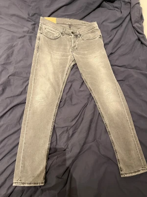 Grå skinny jeans från Dondup - Gråa snygga dondup med fabriks slitningar, storlek 33 och fint skick, hör av er gärna och ställ frågar, kan gå ner i pris vid snabb affär!!