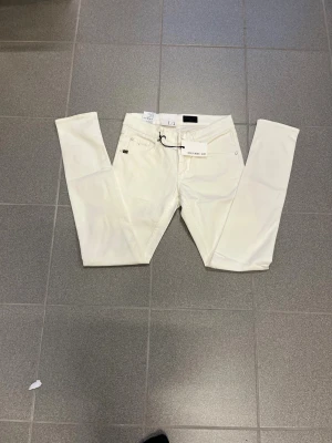 Vita slimmade jeans från Tiger of sweden W29 L32 - Snygga vita jeans från T/J i storlek W29 L32. klassisk femficksdesign och bälteshällor. Perfekt för dig som gillar en slim och modern look. Materialet är mjukt och stretchigt för extra komfort. Nya 