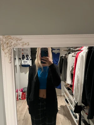 Svart kofta från Atmosphere - Mysig svart kofta från Atmosphere i storlek 36. Koftan är långärmad och har en loose passform med två stora fickor framtill. Materialet är fluffigt och stickat, perfekt för kyliga dagar. Enkel och stilren design som funkar till många outfits. Knappt använd.