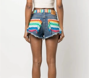 Alanui denimshorts med regnbågsdetaljer - Unika jeansshorts från Alanui med färgglada virkade regnbågsdetaljer på bakfickorna och midjan. Köpte dem för ungefär 19 000kr på Farfetch, helt oanvända. Tar emot bud.