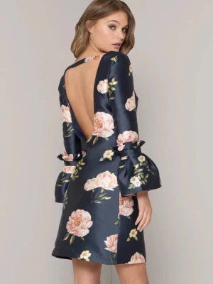 Mörkblå blommig klänning med öppen rygg - Supersnygg mörkblå kortklänning i satin med stora blommor i rosa och vitt. Klänningen har långa trumpetärmar med volangdetaljer och en djup öppen rygg. Storlek UK 10 - S/M - 38