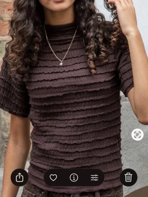 Brun ribbad topp från & Other Stories - Säljer en brun ribbad topp från & Other Stories i storlek XS. Toppen har korta ärmar, hög hals och ett coolt rynkat tyg med vågiga ribbor som ger en unik struktur. Perfekt att styla med jeans eller kjol för en trendig look. Enbart använd 1 gång. Har 2 andra i likadan tröjor i svart och vinröd i samma strlk. Kan tänka mig att sälja alla 3 st för 160 kr💗