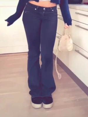 Svarta bootcut jeans med låg midja - Snygga svarta jeans med bootcut-snitt och låg midja. Klassisk femficksmodell med knapp och dragkedja framtill. Jeansen har en stilren look och är tillverkade i ett mjukt jeansmaterial som sitter skönt. Perfekta för dig som gillar en tidlös och cool stil.