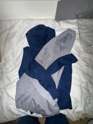Två merinoull hoddie Grå x Blå - Två stilrena merinoull hoddie som aldrig har använts utan bara provat. Hoddien hade passat dem som är 165 och under. Hoddien är gjord av en mjuk och skön o varm material som kan vara bra nu på vinter. Inga defekter också. Hör av dig gärna om du har frågor eller liknade🙌
