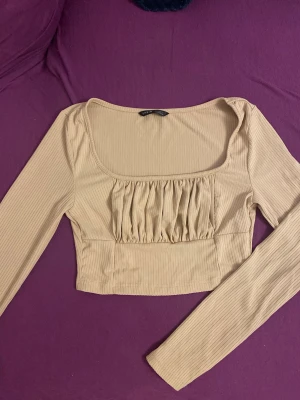 Beige ribbad croppad topp - Beige ribbad croppad topp från SHEIN. Står strl S men personen på bilden är Xs / xxs så funkar lika bra på de strl med!!