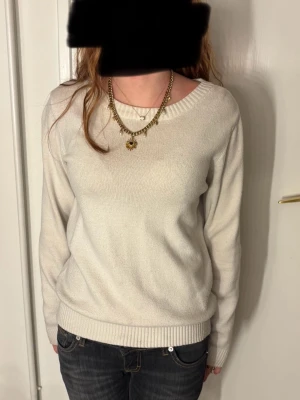 Vit stickad tröja  - Säljer en enkel och stilren vit stickad tröja med rundad halsringning och ribbade muddar vid ärmslut och nederkant. Perfekt att matcha med jeans eller kjol för en clean look. Tröjan har lång ärm och är mjuk i materialet.