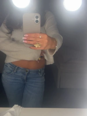 Bootcut ljusblå jeans - Säljer ett par ljusblå bootcut jeans med låg midja. Jeansen har en snygg passform som sitter tajt upptill och släpper vid benen. Materialet är jeans och färgen är fräscht ljusblå.