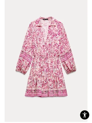 Blommig kortklänning från Zara - Superfin kortklänning från Zara med rosa och vita blommor, v-ringning och långa ärmar. Klänningen har markerad midja och volang nertill, perfekt för sommarens alla tillfällen. Lätt och luftig i bomullsmaterial.