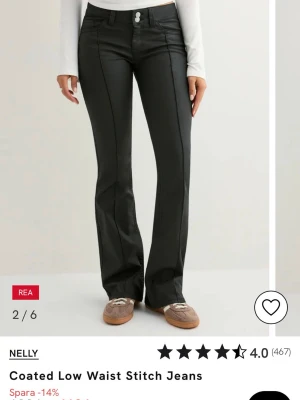 Svarta coated low waist jeans från Nelly - Snygga svarta jeans med coated finish från Nelly. Modellen har låg midja, raka ben med lätt bootcut och markerade sömmar framtill. Jeansen har klassiska fickor och en cool, glansig yta som ger en trendig look.