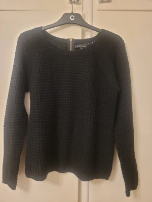Svart stickad tröja från ONLY med dragkedja - Säljer en svart stickad tröja från ONLY i storlek M. Tröjan har ett grovt stickat mönster och en snygg dragkedja i nacken som detalj. Rund halsringning och långa ärmar gör den perfekt för kyligare dagar. Enkel att matcha med jeans eller kjol.