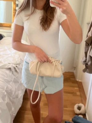 Ljusblå jeanskjol med asymmetrisk kant - Säljer en ljusblå jeanskjol med snygg asymmetrisk kant framtill. Kjolen är kort och har en klassisk denimlook som är enkel att matcha med olika toppar. Perfekt för dig som gillar en avslappnad och trendig stil.