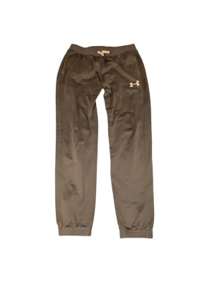 Gråa byxor från Under Armour XS - Säljer ett par gråa mjukisbyxor från Under Armour i storlek XS Byxorna har elastisk midja och muddar vid bensluten, samt en diskret logga på höften. Materialet är mjukt och skönt, perfekt för chill eller träning. Loose fit för extra komfort.