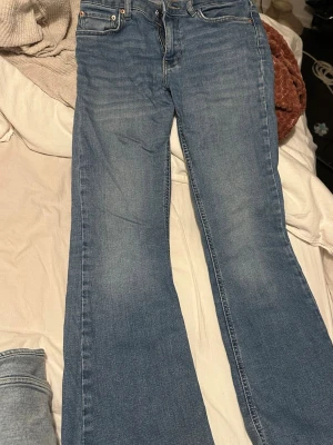Blå bootcut jeans från Perfect Jeans - Säljer ett par klassiska blå bootcut jeans från Perfect Jeans i storlek 36. Jeansen har fem fickor, dragkedja och knapp framtill samt bälteshällor. Materialet är jeans med en snygg tvättad look och raka ben som blir bredare nedtill.