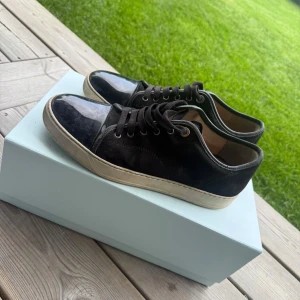 Svarta sneakers från Lanvin i mocka - Snygga svarta sneakers från Lanvin med ovandel i mocka och glansig tå. Köpta från Care of Carl Storlek 43, sitter som 44, box ingår mitt pris 2399kr. 