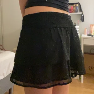 Svart glittrig Volangkjol  - Super din glittrig volangkjol! Säljer då den inte kommer till användning. Ganska ”stretchig” vilket är super bra. Kan användas som tubtopp också🤍