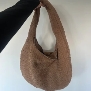 Väska - Säljer en brun flätad axelväska från Gina Tricot. Sååå himla snygg men kommer tyvärr inte till användning. Aldrig använd!🤎 Helt perfekt nu till hösten