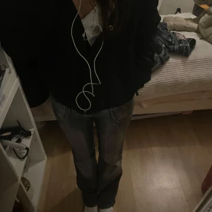 mörkgrå / blåa bootcut jeans - Säljer ett par jättesnygga levis 505 jeans i mörkgrå/mörkblå tvätt med snyggt slitna detaljer. Modellen har klassisk bootcut med normal passform och fem fickor. Jeansen är i bomull och har tydliga sömmar och dragkedja framtill.