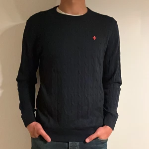 Mörkblå stickad tröja från Morris - Snygg mörkblå kabelstickad tröja från Morris i storleken XL (L/XL). Nypris: 1899kr. Vårt pris: 449kr. Modellen är 190cm och väger 81kg. Hör av er vid frågor/fler bilder!