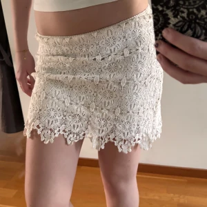Vit virkad kjol - En vit/creme färgad kjol som har virkat tyg på utsidan. På insidan är det skönt material och-element dragkedja finns på sidan!🩷 Storleken är 38 men skulle säga att den är S om man vill att midjan ska sitta vid ens höfter