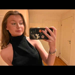 Svart topp - Säljer en svart polotopp med hög krage och ärmlös, axelbandslös design. Storlek S