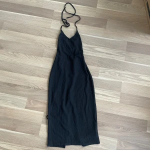 Svart klänning  - Elegant svart långklänning från SHEIN med smala axelband och en stilren design. Klänningen har en v-ringad hals och snörning i ryggen för en extra detalj. Storlek M men är mer nåt S, så passar någon mellan S och M