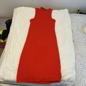 Röd ribbad klänning från Bik Bok - Säljer en snygg röd ribbad kortklänning från Bik Bok i storlek S. Klänningen är ärmlös med rund halsringning och har en tight passform som framhäver figuren. Perfekt för dig som gillar en enkel men stilren look.