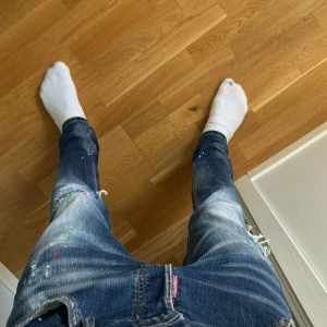 Dsquared2 jeans - Säljer ett par blå Dsquared2 jeans med feta slitningar och paint splatter.                                        Nypris ca 3000kr.                                               Storlek: 50 som är 32/32 men passar 31