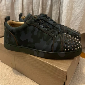 Olivfärgade Camo Louboutins - Säljer dessa snygga unika Loutbotins. Dessa skor är min killes då det är man skor. Säljs pågrund av att de inte kommer till användning. Skorna har inga defekter och är i bra skick. Köpt ifrån en annan som sålde dessa. Detta är en väldigt eftertraktad och sällsynt sko då fe inte finns många med denna unika modell. Även låda och påse för skorna ingår vid köp. Skriv för flera bilden eller frågor😁