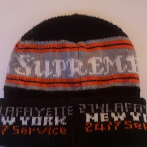 Supreme Beanie FW19 – Limited Edition –  - Supreme Beanie FW19 – Limited Edition – New York / Phone Number Design  Beskrivning: Säljer en äkta Supreme mössa från Fall/Winter 2019-kollektionen. Modellen har den ikoniska block-loggan “SUPREME” samt textdetaljer med New York och nummer-print längs kanten. 	•	Äkta Supreme (köpt 2019) 	•	Storlek: One Size 	•	Färg: Svart / Grå / Orange 	•	Skick: Mycket bra, använd sparsamt (se bilder) 	•	Inköpspris: ca 400 kr (retail)  Perfekt för dig som samlar på Supreme eller vill ha en limiterad streetwear