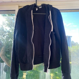 Svart hoodie med dragkedja - Svart hoodie med vit dragsko och hel dragkedja framtill.  Passar mer S/M men de står storlek L