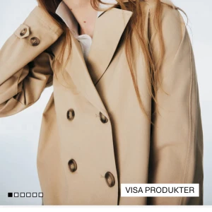 Beige trenchcoat med knappar - Stilren beige trenchcoat med dubbelknäppning och klassisk krage. Jackan har långa ärmar och stora knappar framtill, perfekt för en trendig och tidlös look. Passar dig som gillar minimalistisk stil och vill ha en jacka som funkar till många outfits.