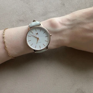 Klocka  - Boulevard vit/läder, 38mm. Använd men i gott skick, inga repor på glaset. Dock finns någon missfärgning på klockbandet (se bild). Behöver nytt batteri.  Nypris 1085kr