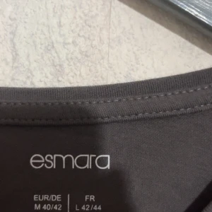 Mörkgrå långärmad tröja Esmara - En basic mörkgrå långärmad tröja från Esmara i mjuk bomull. Enkel och stilren med rund halsringning, perfekt att matcha med jeans eller kjol. Skön passform och passar till många olika outfits.