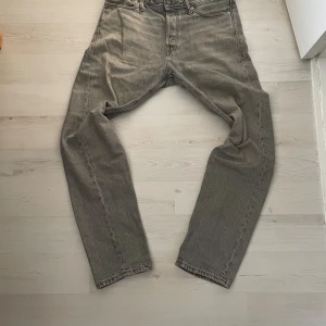Jack & Jones jeans - Tja, säljder dessa jeans från Jack & Jones. Grå design med populär straight passform. W29 L32. Säljer pga att de ej används längre plus att dem är för små. Nypris runt 700, mitt pris 300! Priset är alltid diskuterbart, hör av er vid frågor! 