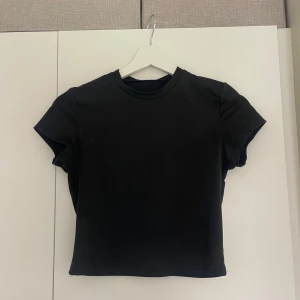 Svart croppad t-shirt - En stilren svart croppad t-shirt med rund hals och korta ärmar. Perfekt för att matcha med jeans eller kjol🖤🖤