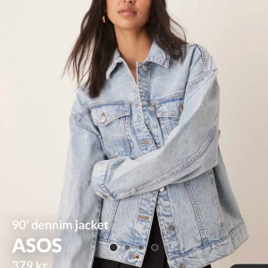 Oversized jeansjacka från ASOS - Säljer en ljusblå oversized jeansjacka från ASOS med klassisk krage, knappar framtill och två bröstfickor med lock. Jackan har en avslappnad passform och långa ärmar, perfekt för en cool och avslappnad stil.