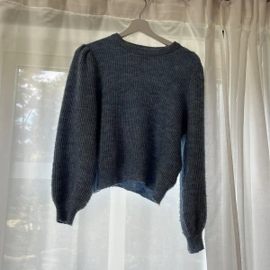 Mörkblå stickad tröja  - Mysig mörkblå stickad tröja med ribbad struktur. Rund halsringning och något lös passform ger en avslappnad vibe.