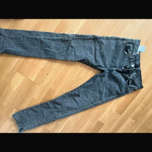 Levi's 501 grå jeans straight fit - Säljer ett par Levi's 501 Premium jeans i snygg grå tvätt. Klassisk rak passform med fem fickor, knappgylf och detaljer i silver. Jeansen är tillverkade i bomull med lite stretch för extra komfort. Perfekta till sneakers eller boots.