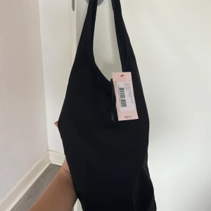 Svart topp från Nelly med halterneck - Snygg svart topp från Nelly med halterneck och öppen i ryggen, helt ny. 