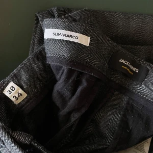 Grå kostymbyxor Jack & Jones - Snygga grå kostymbyxor från Jack & Jones i modellen Marco. Väldigt bra skick på dessa och framför allt skönt material. Sitter som en smäck! Säljes åt min pojkväns lillebror då han har växt ur dom. Passar någon som är runt 185 cm❣️❣️❣️