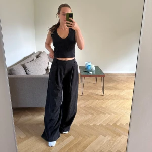 Svarta vida byxor med hög midja - Säljer ett par svarta byxor med hög midja och riktigt breda ben. Byxorna har en klassisk look med knapp och dragkedja framtill samt fickor på sidorna. Perfekta för dig som gillar en loose och trendig stil. Materialet känns mjukt och följsamt.