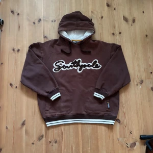 Southpole hoodie - Vintage brun southpole hoodie i storlek XL, perfekt baggy fit enligt mig. I princip nyskick utan tecken på användning. Mått: längd 68cm(luva ej inkluderad), bredd 63cm. Kontakta för mer info och pris kan diskuteras!