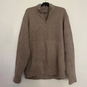 Beige stickad half zip-tröja Uniqlo - Beige ribbad stickad tröja från Uniqlo med half zip-dragkedja. 