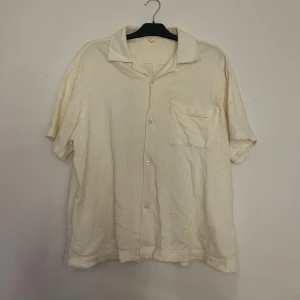 Kortärmad skjorta i frotté  - En krämvit skjorta i frotté med korta ärmar. Från Arket