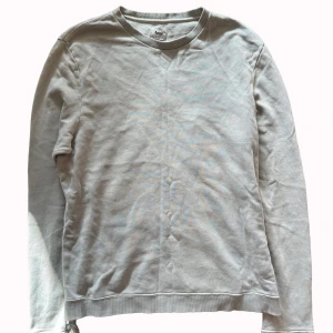 Ljusgrå sweatshirt från Acne Studios - En stilren ljusgrå sweatshirt från Acne Studios Pop Classics. Tröjan har rund halsringning, ribbade muddar och är tillverkad i mjuk bomull. Perfekt för en clean och avslappnad look.