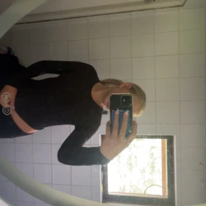 Svart långärmad topp med öppen rygg - Säljer en svart långärmad topp med snygg croppad passform. Baksidan har öppen rygg med coola korsade band och knytning i midjan. Perfekt för dig som vill ha en stilren men ändå unik look. Från NLY TREND i storlek S❣️❣️